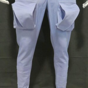 Puede incluir: Pantalones cargo de color azul claro con dos bolsillos de parche grandes y prominentes en la parte delantera de los muslos. Los pantalones tienen un corte recto con un acabado de color s&oacute;lido y detalles de costuras visibles en la parte inferior.