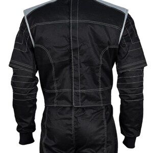 May include: Black racing suit with white stitching and gray accents on the shoulders and collar. The suit has long sleeves with ribbed cuffs and a full-length zipper. The suit is designed for motorsports.