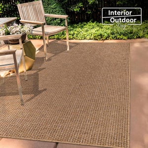 Flat-lay photo of a 160x230 cm beige rug on a tiled floor. The natural-looking texture enhances the overall warmth of the space and provides a stylish yet functional base layer for any room.
