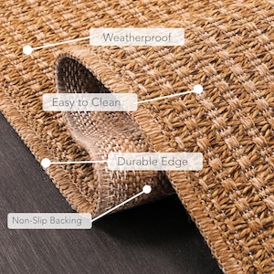 Beige indoor outdoor rug placed in a modern living room setting, complementing neutral-toned furniture and wood flooring. The polypropylene material is weatherproof, washable, and easy to maintain, making it ideal for everyday use in busy homes.