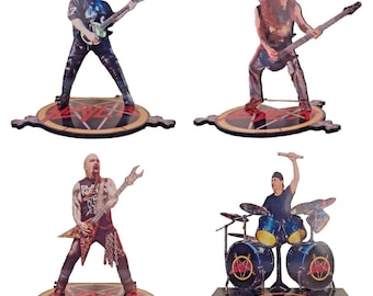 May include: Four-piece set of Slayer band member figurines. Each figure is a cutout of a band member playing their instrument. The figures stand on a wooden base with a pentagram design and the word "SLAYER".
