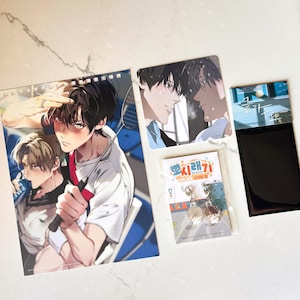May include: A collection of anime-style merchandise including a large rectangular print featuring two characters with a badminton racket, a square card with two characters, a small acrylic charm set in packaging, and a black rectangular card holder.