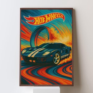 May include: A framed print featuring a blue sports car with white stripes, speeding along a colorful track. The Hot Wheels logo is displayed at the top, with a retro design in shades of blue, orange, and yellow.