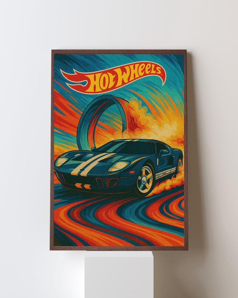 May include: A framed print featuring a blue sports car with white stripes, speeding along a colorful track. The Hot Wheels logo is displayed at the top, with a retro design in shades of blue, orange, and yellow.
