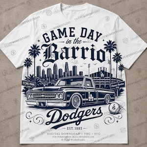 May include: White t-shirt featuring a navy blue graphic design. The design includes the text "Game Day in the Barrio" above a vintage truck, the word "Dodgers", and a baseball. The shirt also has the text "Est. 1883".