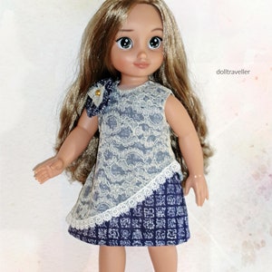 May include: A doll with long brown hair wearing a white and blue lace dress with a white lace trim. The doll is wearing white crocheted shoes.