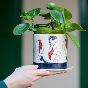 Hand-painted ceramic planter with sequential illustrations of a forward roll with a drainage hole and saucer image 1