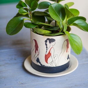 Hand-painted ceramic planter with sequential illustrations of a forward roll with a drainage hole and saucer image 2