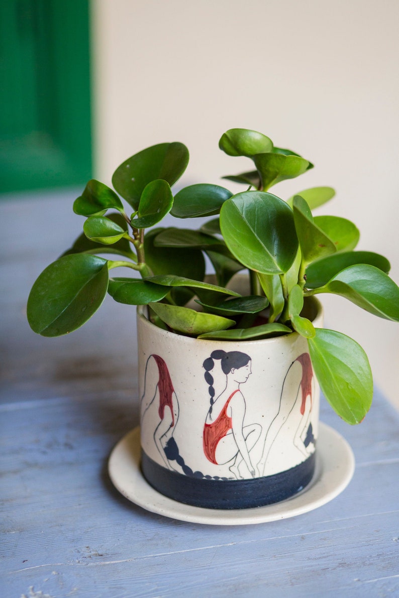 Hand-painted ceramic planter with sequential illustrations of a forward roll with a drainage hole and saucer image 2