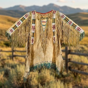 May include: A tan-colored, fringed garment with intricate beadwork and decorative patterns. The sleeves and hem are adorned with long fringe. The beadwork features red, white, yellow, and blue accents. The garment is likely Native American-inspired.