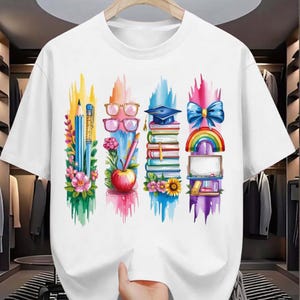 Puede incluir: Camiseta blanca con un dise&ntilde;o gr&aacute;fico colorido. El dise&ntilde;o incluye un l&aacute;piz, gafas, un birrete, un lazo, un arco&iacute;ris, libros, flores y una manzana. El gr&aacute;fico est&aacute; sobre pinceladas verticales en varios colores.