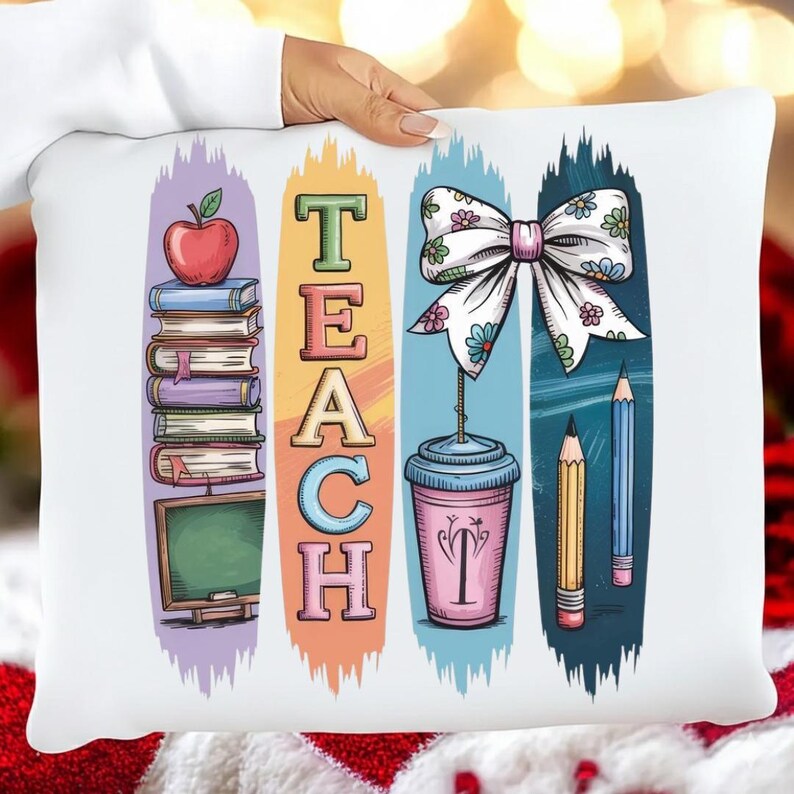 Puede incluir: Coj&iacute;n rectangular blanco con un dise&ntilde;o TEACH colorido. El dise&ntilde;o incluye una manzana, libros, una pizarra, un lazo, una taza de caf&eacute; y l&aacute;pices. Las letras son de diferentes colores y el fondo tiene trazos verticales.