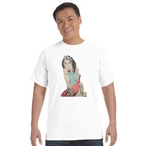 May include: White t-shirt featuring a colorful illustration of a woman in a seated pose. The artwork uses red, blue, and gray tones. The t-shirt is made of a soft, comfortable material.