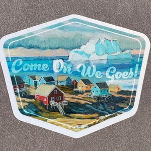 May include: A hexagonal sticker depicting a coastal village with colourful houses and an iceberg. The text "Come On We Goes!" is written across the water in a teal font.