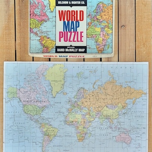 May include: A vintage "World Map Puzzle" by Selchow & Righter Co. The box displays a colourful world map design with the text "World Map Puzzle." The puzzle is laid out, showing the continents and oceans. The official Rand McNally map is used.
