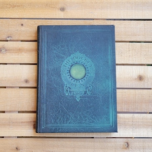 May include: A white ceramic mug with a black handle and the text "But First, Coffee" in a black, bold font. The mug is on a white surface. The mug is approximately 4 inches tall.