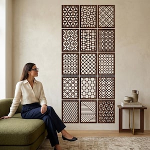 May include: A collection of fifteen square dark brown wooden wall panels arranged in a grid, each featuring a unique laser-cut geometric or linear pattern. The panels are mounted together on a wall to create a large, cohesive decorative display.