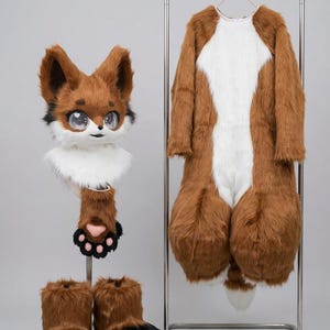 May include: A full fox fursuit set, comprising a head, body suit, hand paws, and feet paws. The costume is made of brown and white faux fur with black detailing. The head has large eyes and the hand paws have pink paw pads.