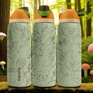 May include: Three insulated water bottles with a light green background and a Tinkerbell design. The bottles have orange and brown lids with a green handle. The bottles have a repeating pattern of Tinkerbell and other fairy-related images. The brand name "owala." is printed on the side.