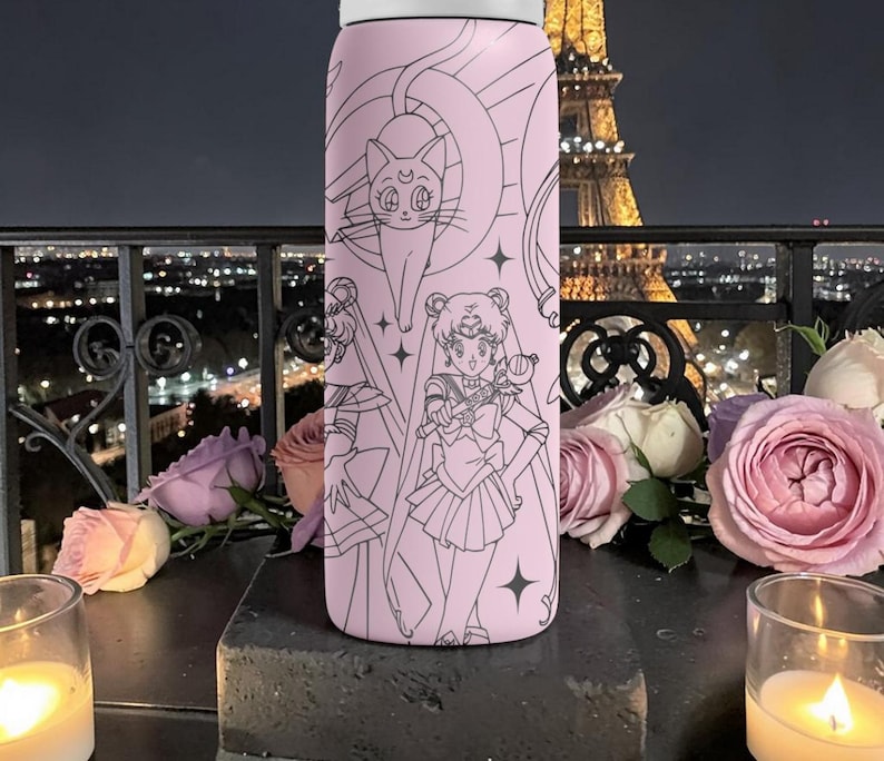 May include: A pink water bottle featuring a black line art design of anime characters and a cat. The bottle is cylindrical with a white lid. The background includes roses, candles, and a city skyline.