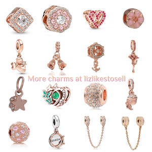 May include: A selection of rose gold charms, featuring a square charm with a clear stone, a floral charm with pink stones, and a heart-shaped charm with red stones. The image also includes charms with bells, stars, and butterflies.