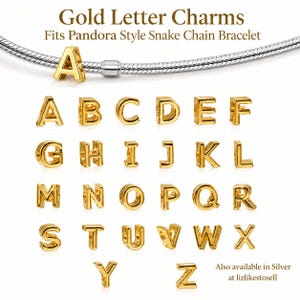 May include: Gold-coloured metal letter charms from A to Z, designed to fit a silver-toned snake chain bracelet. The text Gold Letter Charms Fits Pandora Style Snake Chain Bracelet and Also available in Silver at lizlikestosell is visible.