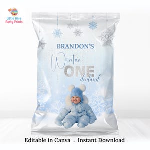 May include: A clear plastic bag with a winter-themed design. The bag features snowflakes, the text "Brandon's Winter One derland", and an image of a baby in a blue snowsuit. The words "Editable in Canva . Instant Download" are at the bottom.