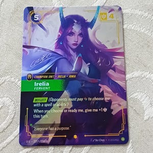 Puede incluir: Una tarjeta coleccionable con Irelia, una Unidad Campeona de Ionia. La tarjeta tiene un borde morado y dorado, con una ilustración de una mujer con cuernos. El texto incluye "Irelia Fervent" e instrucciones del juego.