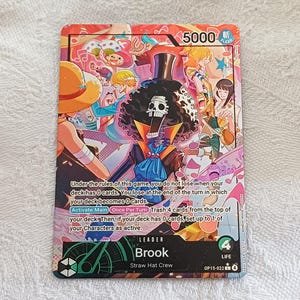 Könnte beinhalten: Eine farbenfrohe Sammelkarte mit Brook von der Strohhut-Crew. Die Karte zeigt eine lebendige Illustration von Brook und anderen Charakteren, mit dem Text "5000" und Spielanweisungen. Die Karte ist mit "LEADER" und "LIFE 4" gekennzeichnet.
