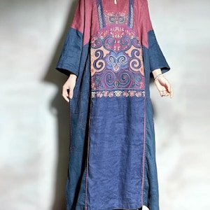 Könnte beinhalten: Ein langes, locker sitzendes Kleid mit einem blauen und rosa Blumendesign. Das Kleid hat einen runden Ausschnitt und Dreiviertelärmel. Das Kleid ist aus einem leichten Stoff gefertigt und perfekt für warmes Wetter.
