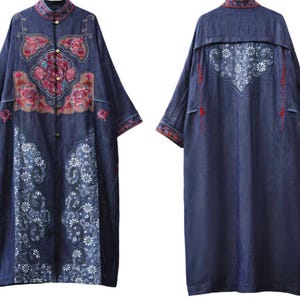 May include: A long, dark blue denim dress with intricate floral embroidery in pink, red, and white. The dress features a mandarin collar, button closures, and a unique embroidered design on the back. The sleeves and hem are detailed with patterned trim.