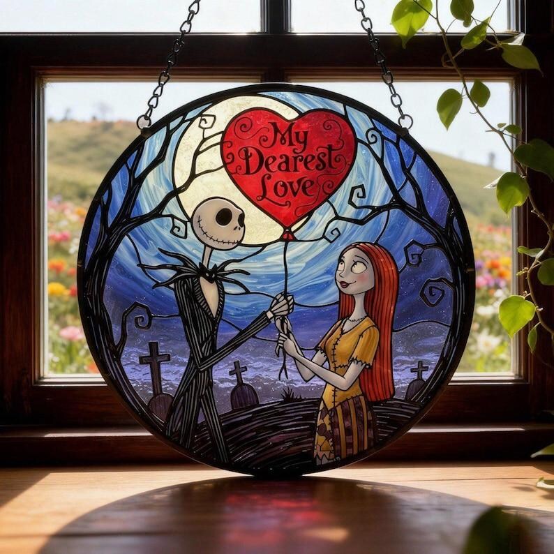 May include: Round stained glass window art featuring Jack Skellington and Sally from The Nightmare Before Christmas. Jack holds a heart-shaped balloon with "My Dearest Love" on it. The background shows a graveyard, moon, and blue sky.