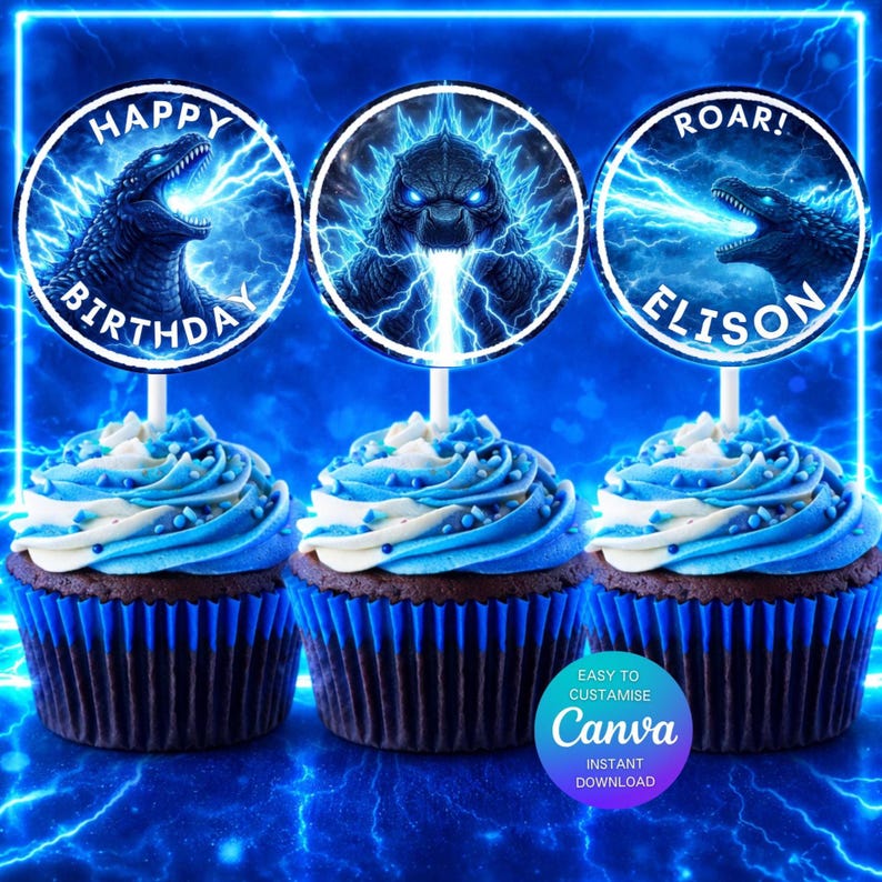 May include: Three cupcakes with blue frosting and Godzilla-themed toppers. The toppers feature Godzilla illustrations with text that reads "Happy Birthday" and "Roar! Elison". The cupcakes are in blue liners.