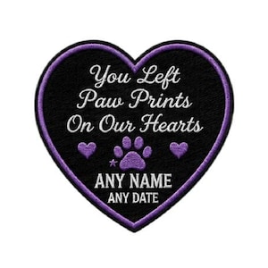 Op de afbeelding: Een hartvormige patch met een zwarte achtergrond en een paarse rand. De patch bevat de tekst "You Left Paw Prints On Our Hearts" in witte letters, samen met een pootafdruk en een sterontwerp. De onderkant van de patch heeft ruimte voor een naam en datum.