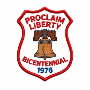 May include: A shield-shaped embroidered patch with a white background and a red border. It features a brown Liberty Bell graphic with blue details, the red text PROCLAIM LIBERTY, the red text BICENTENNIAL, and the blue text 1976 at the bottom.