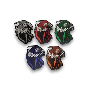 May include: Five Grim Reaper patches in various colours: black, red, green, blue, and orange. Each patch has a black border. The Reaper is shown with a skeletal face and hands, wearing a hooded cloak.