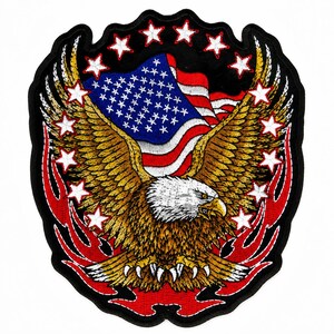 May include: A large embroidered patch featuring a bald eagle with outstretched wings in shades of brown, white, and yellow. Behind the eagle is a waving American flag. The design is surrounded by white stars and red flame-like accents on black.