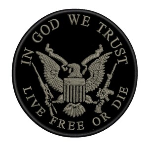 May include: A circular black embroidered patch featuring a central eagle emblem with a shield, flanked by two rifles. The text IN GOD WE TRUST is arched across the top, and the text LIVE FREE OR DIE is arched across the bottom in grey thread.