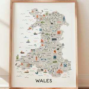 May include: A framed print depicting a detailed illustrated map of Wales. The map includes various icons representing landmarks, animals, and boats. The word "WALES" is prominently displayed at the bottom of the map.