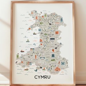May include: A framed print of an illustrated map of Wales, with various icons depicting landmarks and locations. The word "CYMRU" is printed at the bottom. The print is in a light wooden frame.