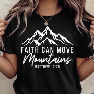 May include: Black t-shirt with a white mountain graphic and the text "FAITH CAN MOVE MOUNTAINS" and "MATTHEW 17:20". The shirt has short sleeves and a crew neck.
