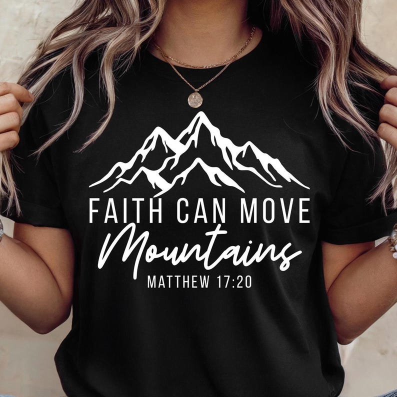 May include: Black t-shirt with a white mountain graphic and the text "FAITH CAN MOVE MOUNTAINS" and "MATTHEW 17:20". The shirt has short sleeves and a crew neck.