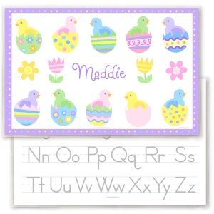 Easter place mat for kids has pastel chicks sitting in colorful Easter eggs shells with child name in the center of the mat.  Border of mat is pastel polka dots, name is in soft purple. Reverse side has alphabet letters.