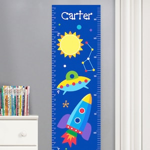 May include: A blue and yellow space-themed growth chart with a rocket, a UFO, planets, and stars. The chart is personalized with the name "Carter" at the top. The chart measures from 60 inches to 160 inches.