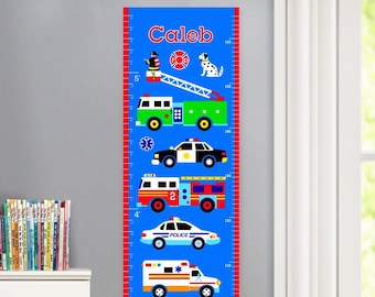 May include: A blue and red growth chart with a blue background and red markings. The chart features a variety of vehicles, including a fire truck, police car, ambulance, and motorcycle. The chart is labeled with the name "Caleb" and has measurements in inches.