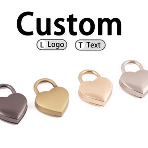 Puede incluir: Cuatro candados en forma de corazón en diferentes acabados metálicos: gris oscuro, dorado, oro rosa y plateado. La palabra "Custom" está encima de los candados, con opciones para "L Logo" y "T Text".