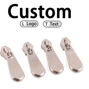 May include: Four silver-colored zipper pulls are displayed against a white background. The word "Custom" is written in black above the zipper pulls. Below the word "Custom" are the words "L Logo" and "T Text" in a circle.