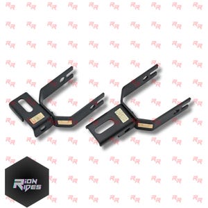 May include: Two black metal brackets with a U-shaped design and gold accents. Each bracket has a rectangular base with a slot and a label, and two prongs extending upwards. The logo "ION RIDES" is in the bottom left corner.