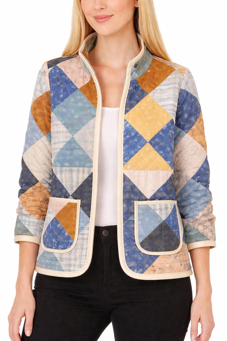 May include: A quilted jacket with a patchwork design in shades of blue, yellow, and brown. The jacket has a cream-colored trim, two front pockets, and a stand-up collar. The sleeves are three-quarter length.