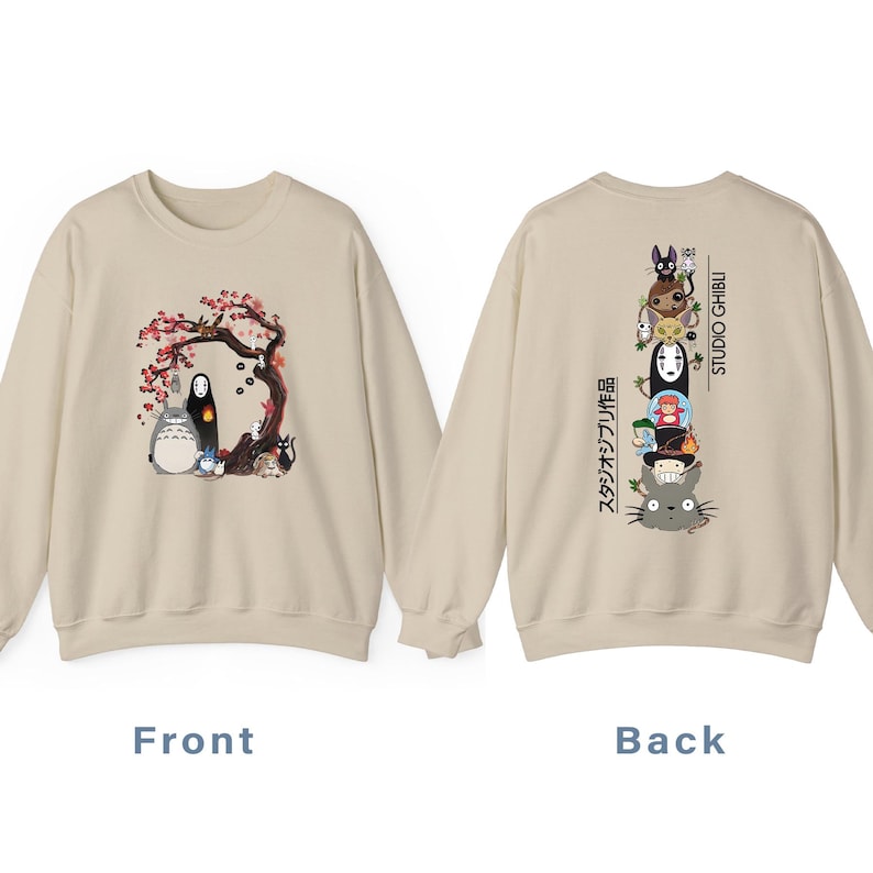 May include: Beige sweatshirt featuring a front graphic of characters under a flowering tree. The back displays a stacked character design with Japanese text and "STUDIO GHIBLI" in white. A cozy, casual garment.